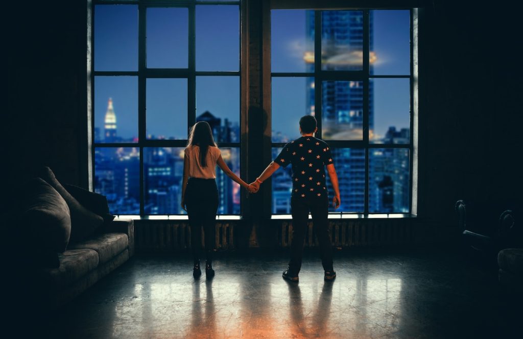 Twin Flame Journey Stages, man and woman holding hands in front of glass window
